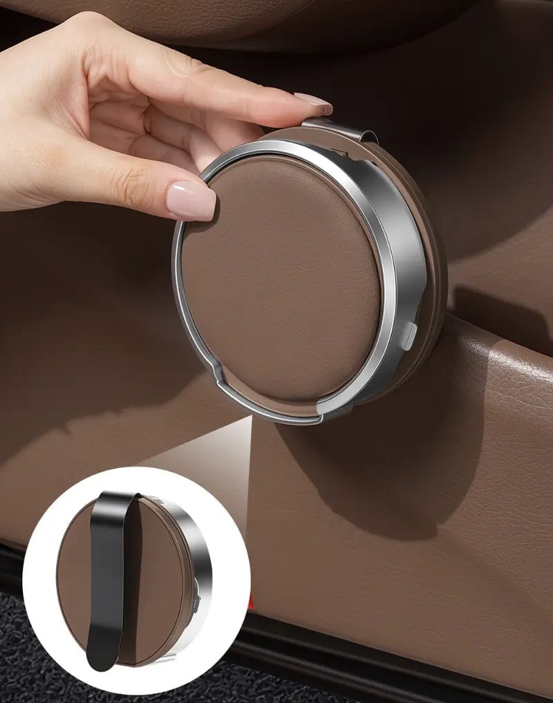 Foldable cup holder folded closed and held in one hand inside the car
