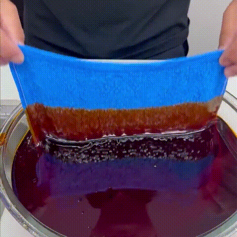 Reusable wood fiber kitchen cloth cleaning grease and rinsing under water