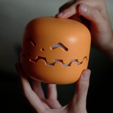 Smiling pumpkin LED night light glowing in a room