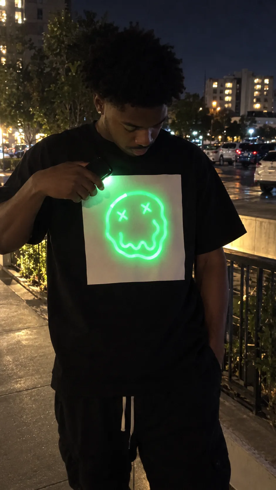 Black Light-Reactive Cotton Tee drawing custom green art with phone light at night