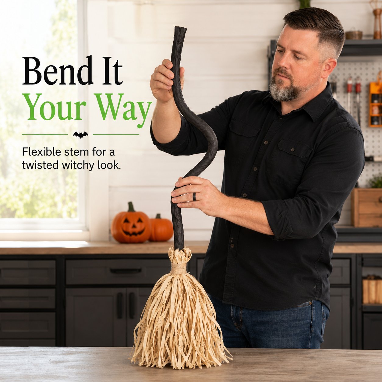 Man bending the flexible black stem of the Halloween broom Man bending the flexible black stem of the Halloween broom