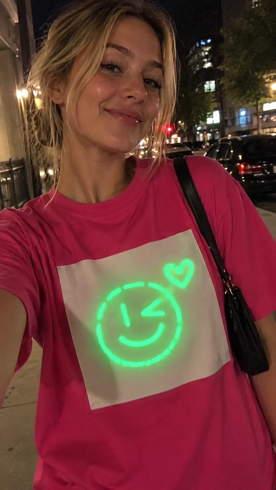 Hot Pink Light-Reactive Cotton Tee glowing green on a night street