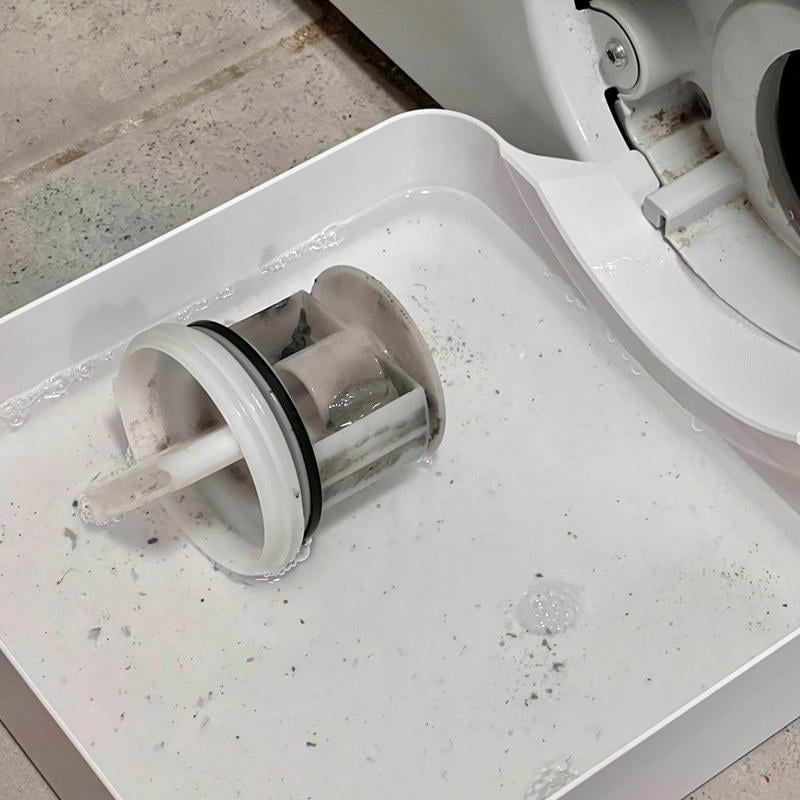 Washing machine filter removal with captured water
