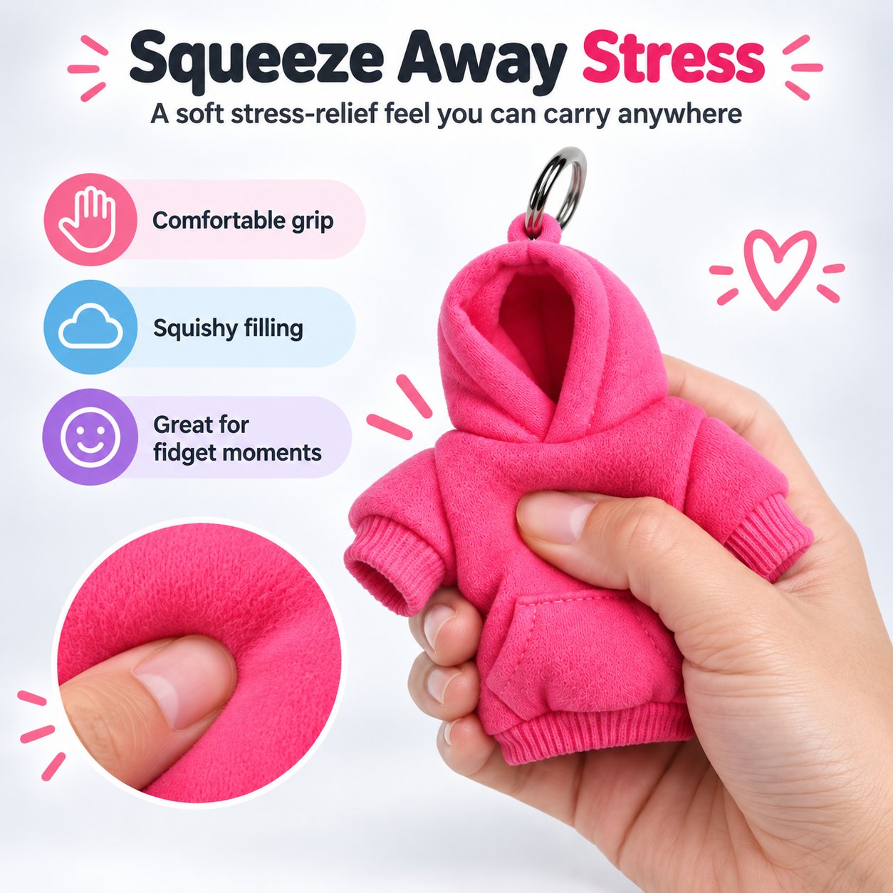 Hand squeezing a pink mini hoodie keychain to show its soft fabric and squishy filling