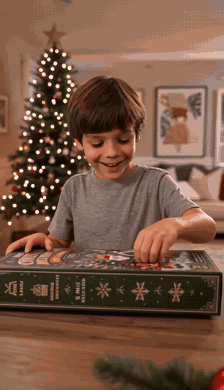 Kind bouwt een figuurtje en hangt het in de kerstboom