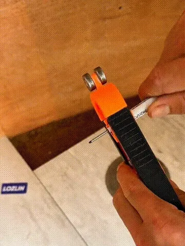 Precision contour gauge tracing an irregular wall profile onto flooring